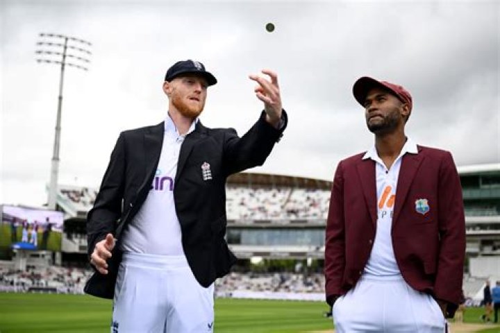 Who toss the coin in cricket match?